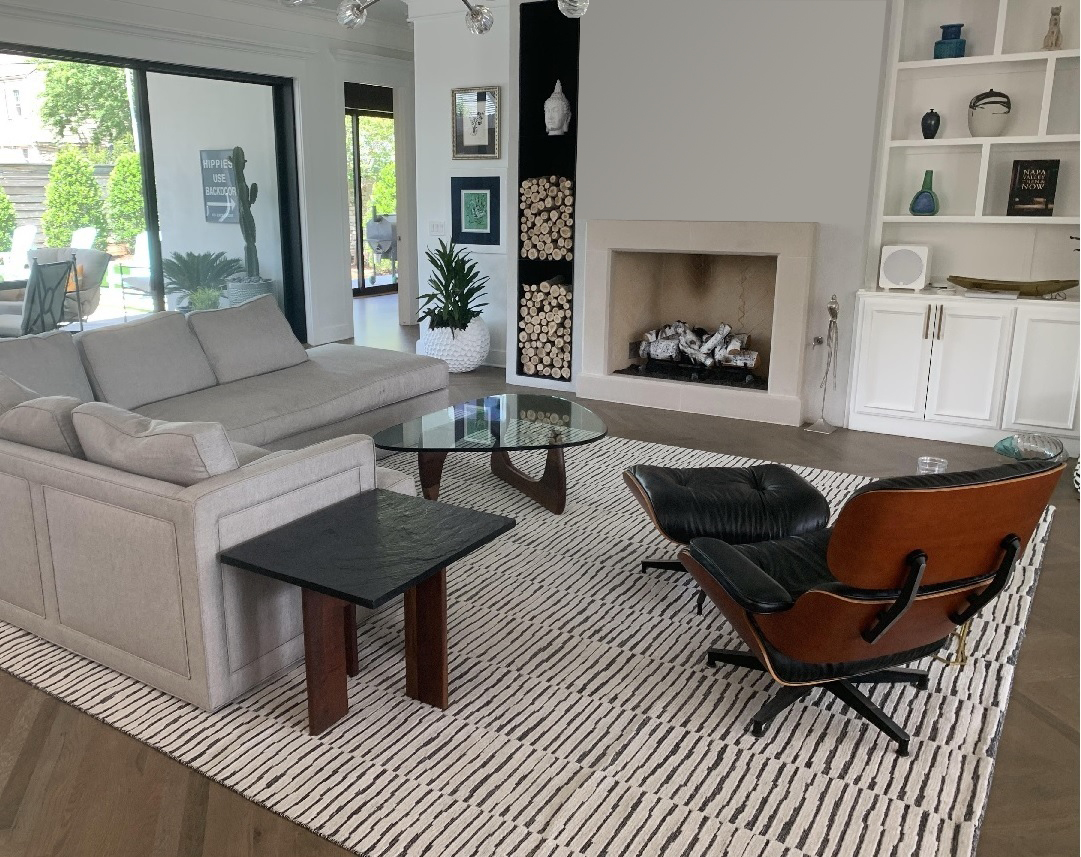 Custom striped rug under a lounge chair and sofa by the fireplace