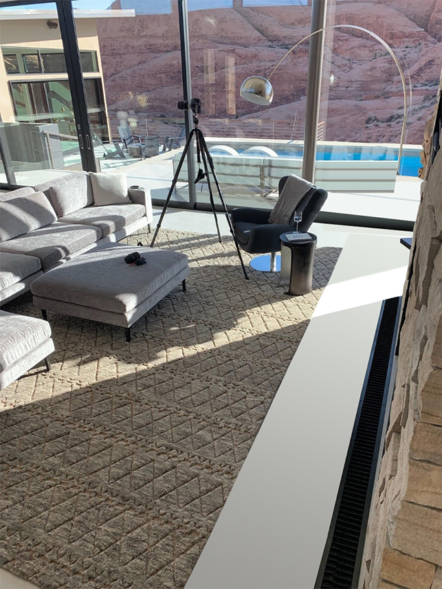 Custom textured rug in a glass-walled great room overlooking desert rock